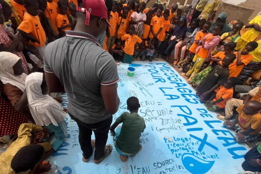 Des visiteurs écrivent leurs messages sur la toile de la Journée mondiale de l’eau 2024.
